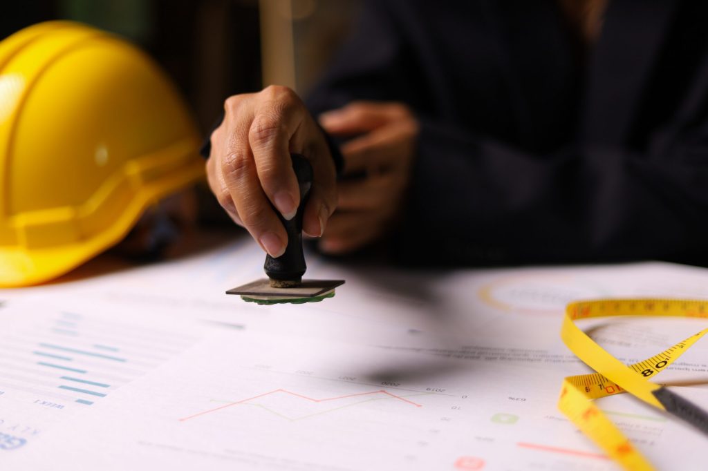 A man stamping a certificate, representing the construction certification industry